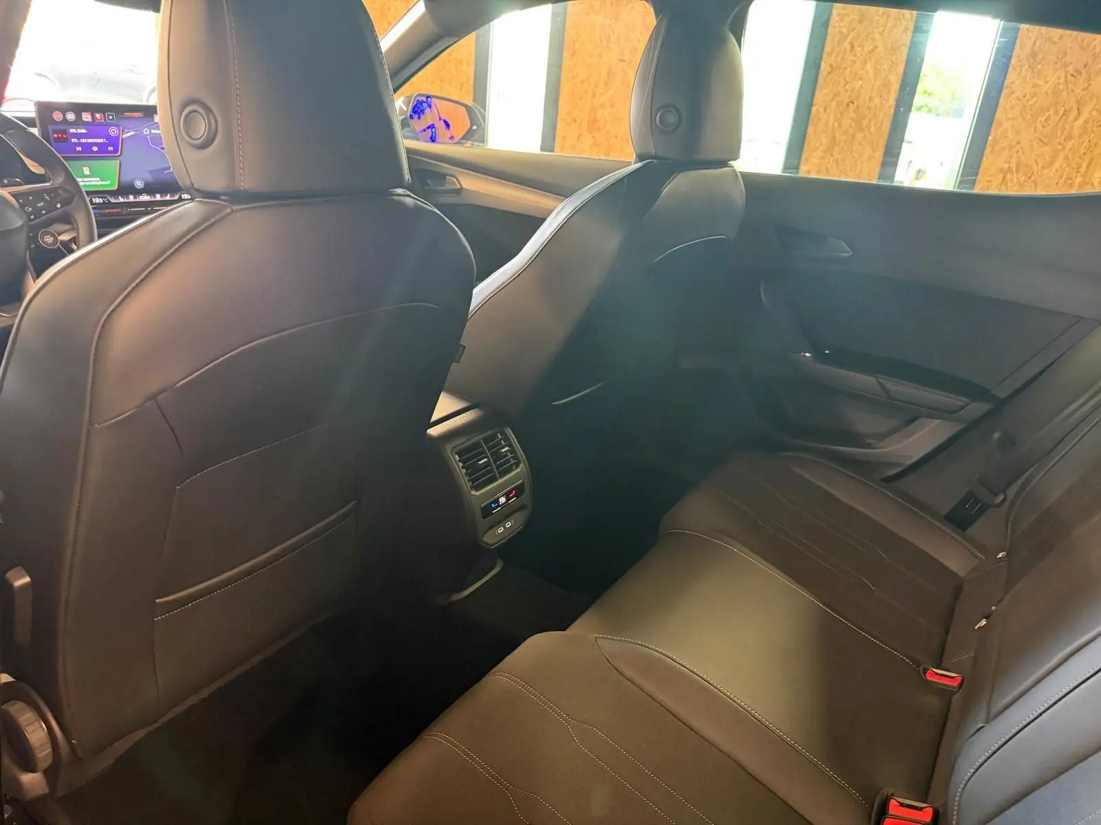 Vue intérieure arrière du CUPRA Formentor 2025 noir, sièges cuir/tissu et console centrale avec aérateurs et commandes climatisation.