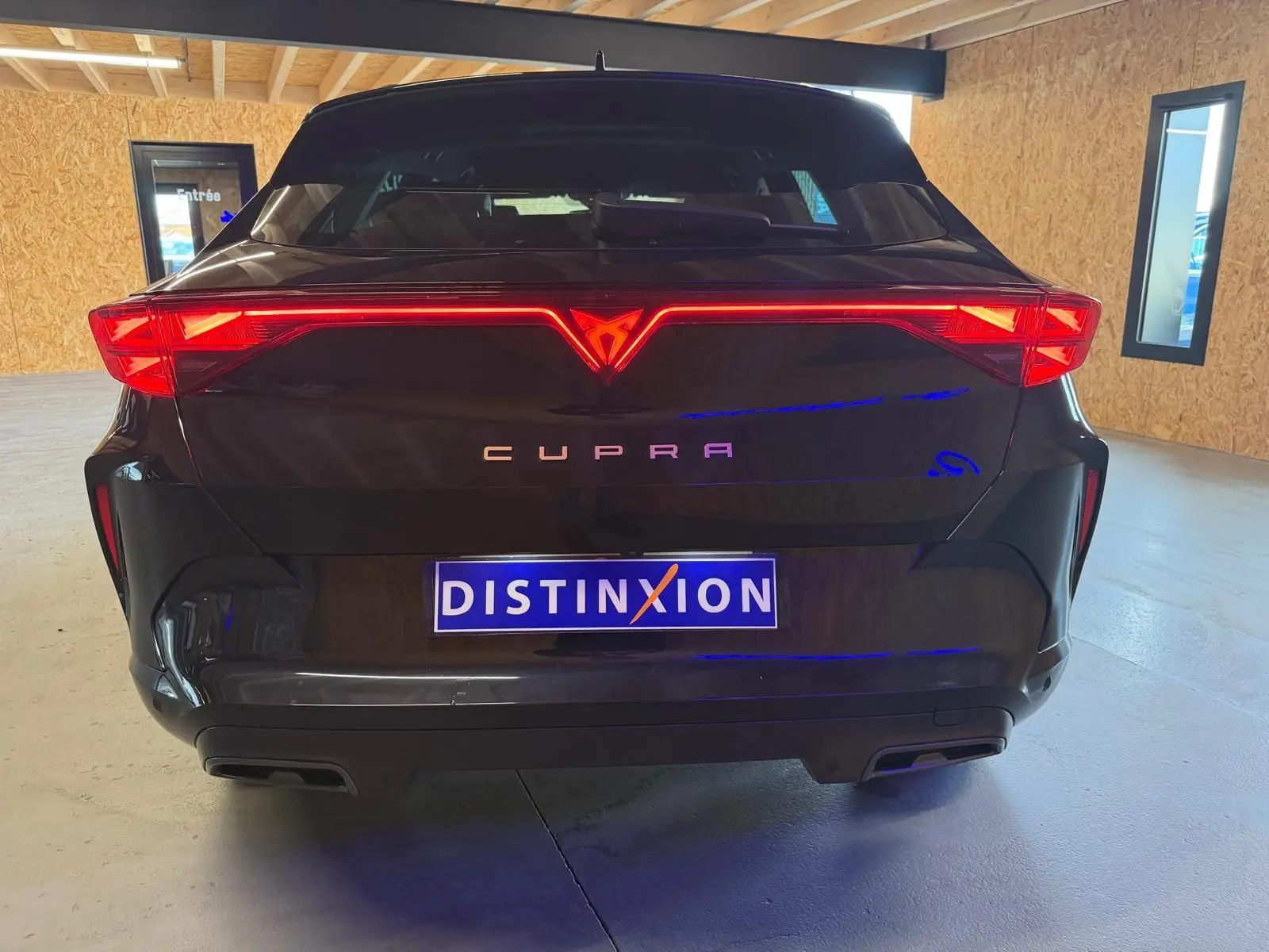 Vue arrière d'un CUPRA Formentor noir 2025 avec feux LED distinctifs et double sortie d'échappement intégrée.