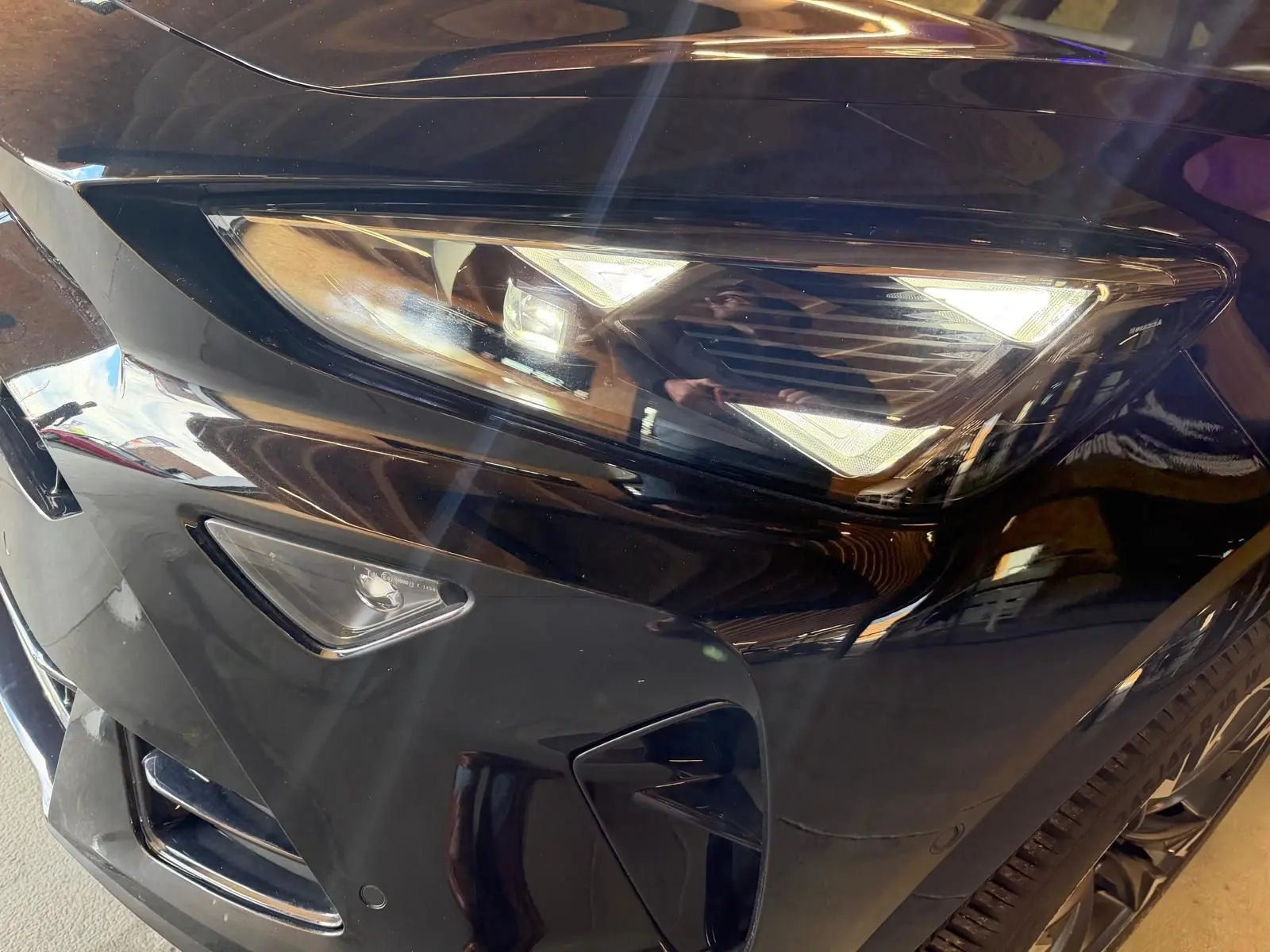 Gros plan sur le phare avant droit noir brillant du CUPRA Formentor 2025 avec jante alliage visible.