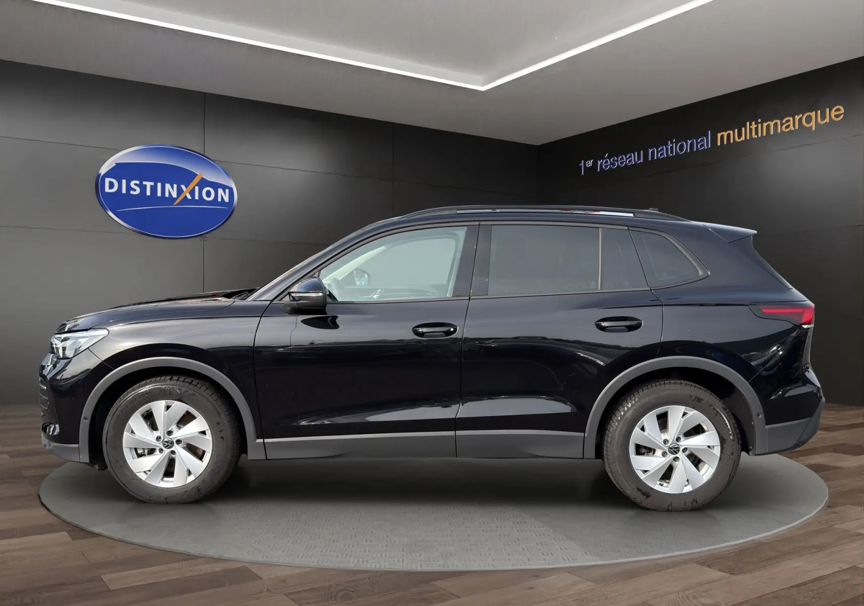Vue latérale droite d'un Volkswagen Tiguan noir 2024, SUV compact avec jantes alliage et vitres légèrement teintées.