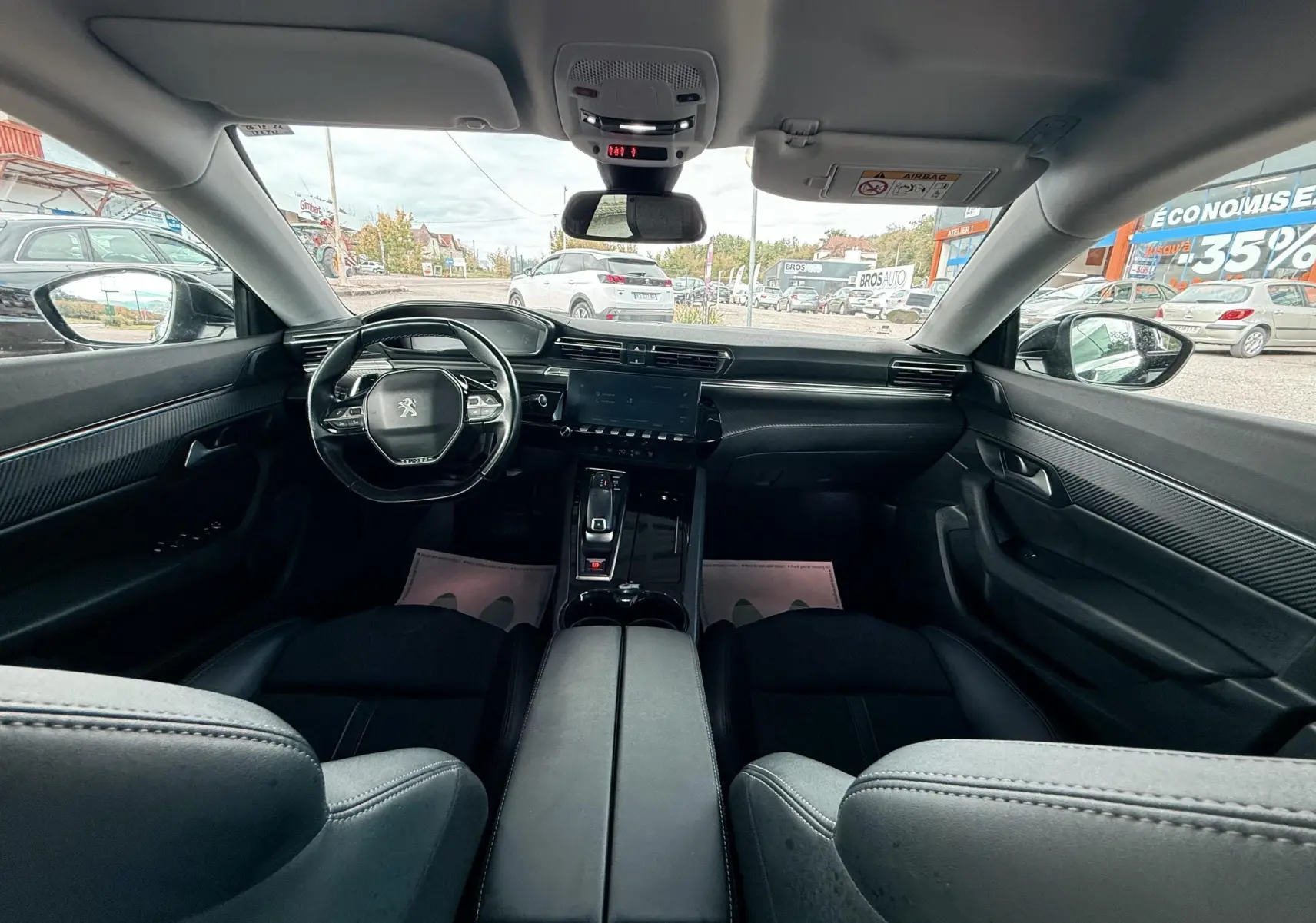 Vue intérieure avant du Peugeot 308 SW noir métal de 2018, montrant tableau de bord moderne et volant compact.