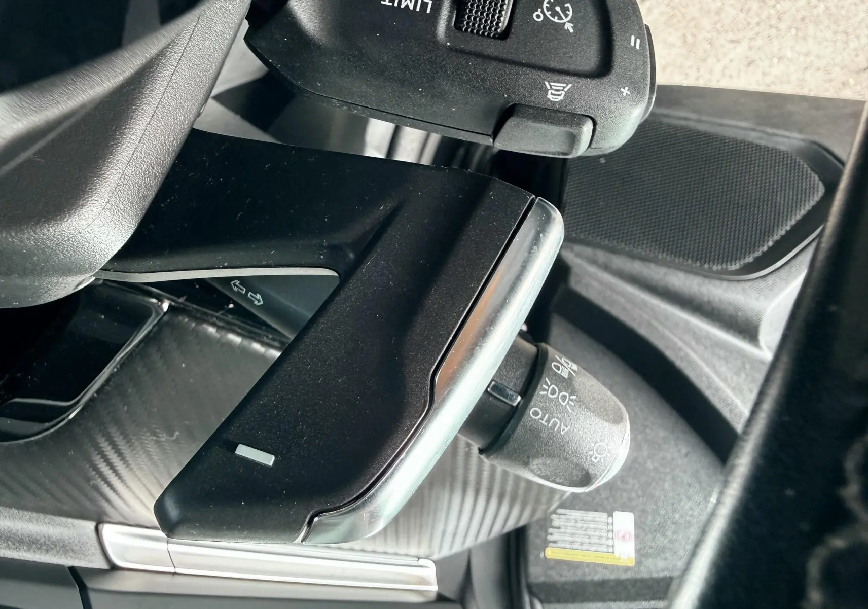 Détail du levier de commande des feux et régulateur de vitesse dans l'habitacle noir du Peugeot 308 SW 2018.