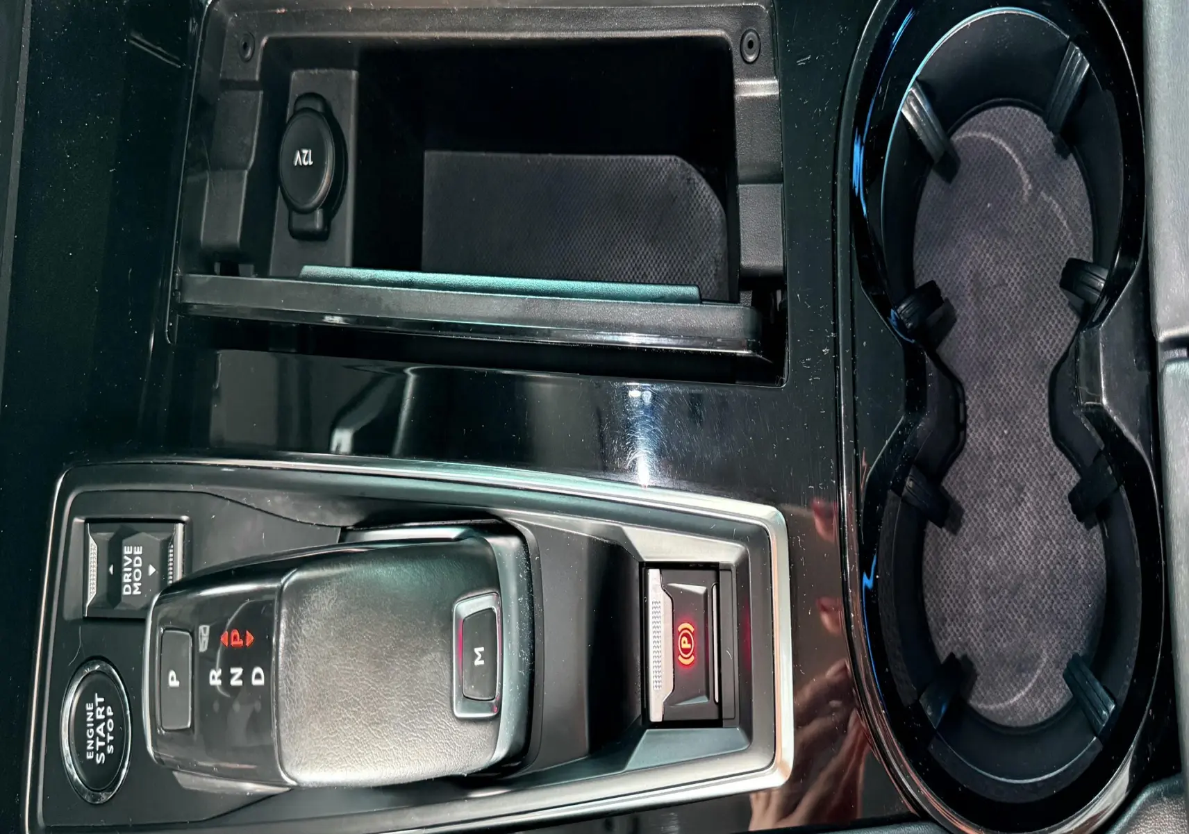 Vue rapprochée de la console centrale noire avec levier de vitesse automatique et porte-gobelets du Peugeot 308 SW 2018.