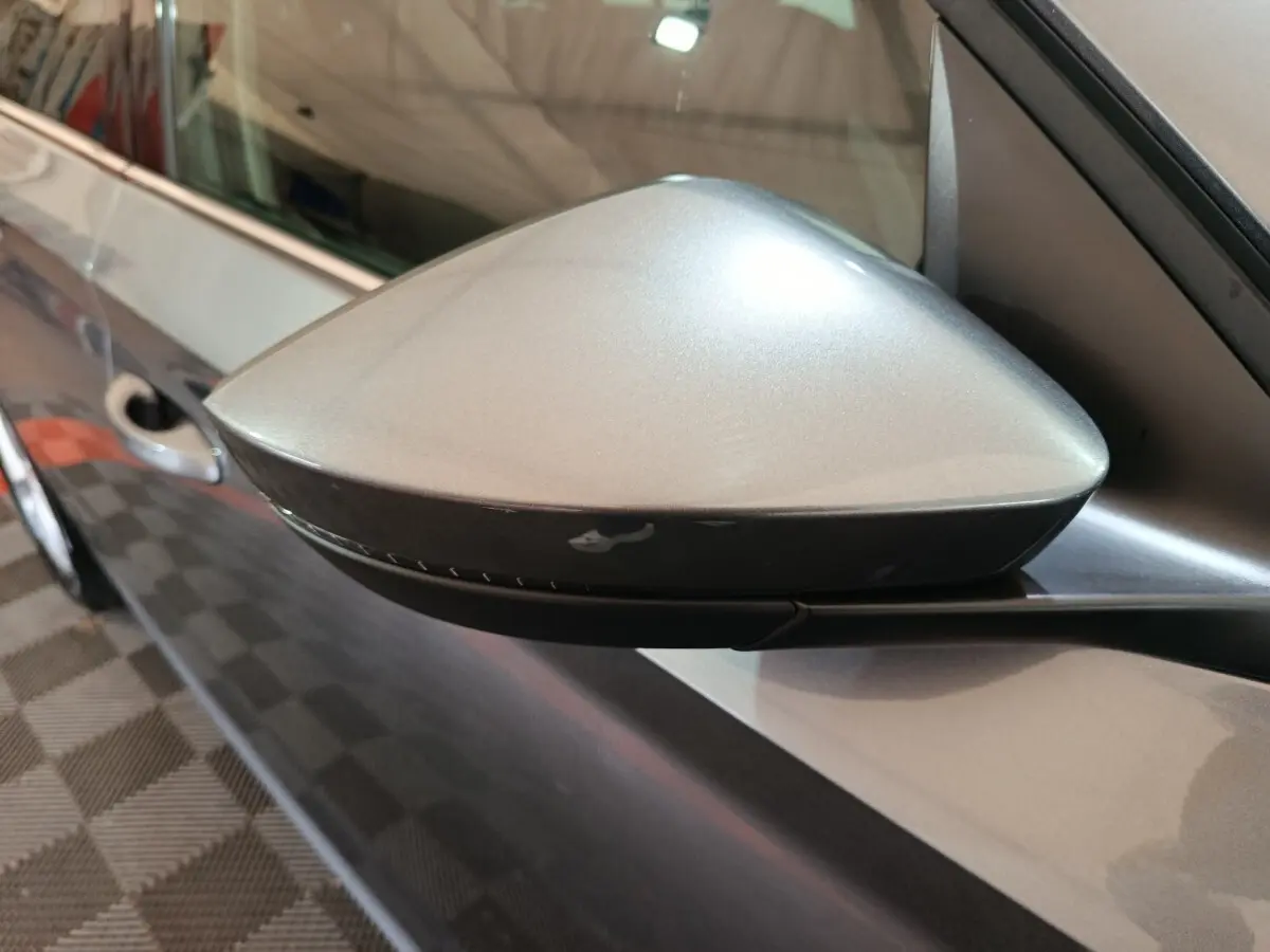 Gros plan sur le rétroviseur droit gris clair d'une Skoda Kamiq 2024, avec carrosserie assortie visible en arrière-plan.