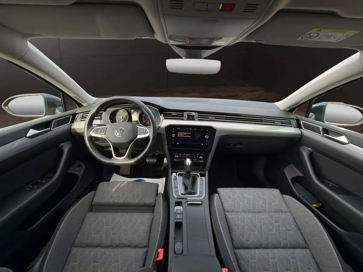 Vue intérieure avant de la Volkswagen Passat 2.0 TDI 2022 avec tableau de bord moderne et sièges gris foncé.