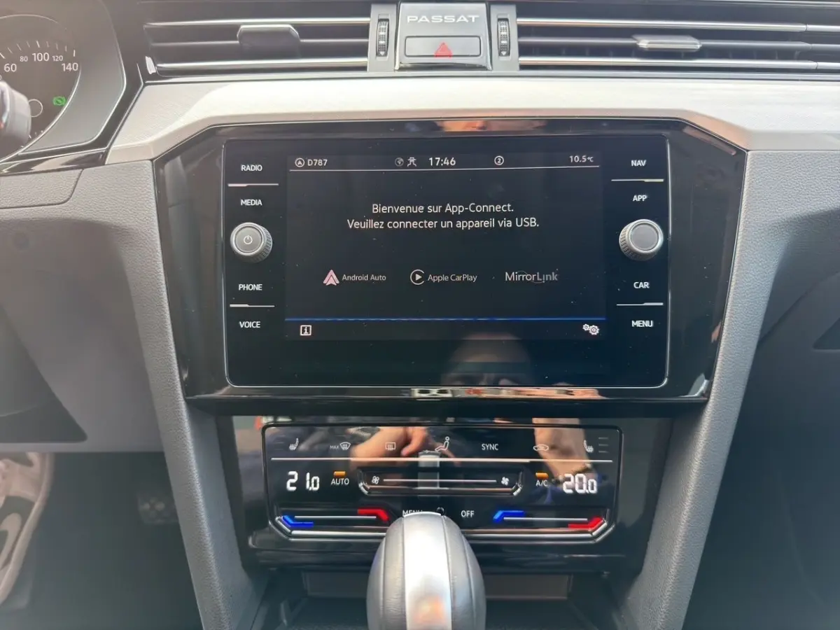 Vue rapprochée du tableau de bord gris foncé de la Volkswagen Passat 2022 avec écran tactile et commandes climatisation digitales.