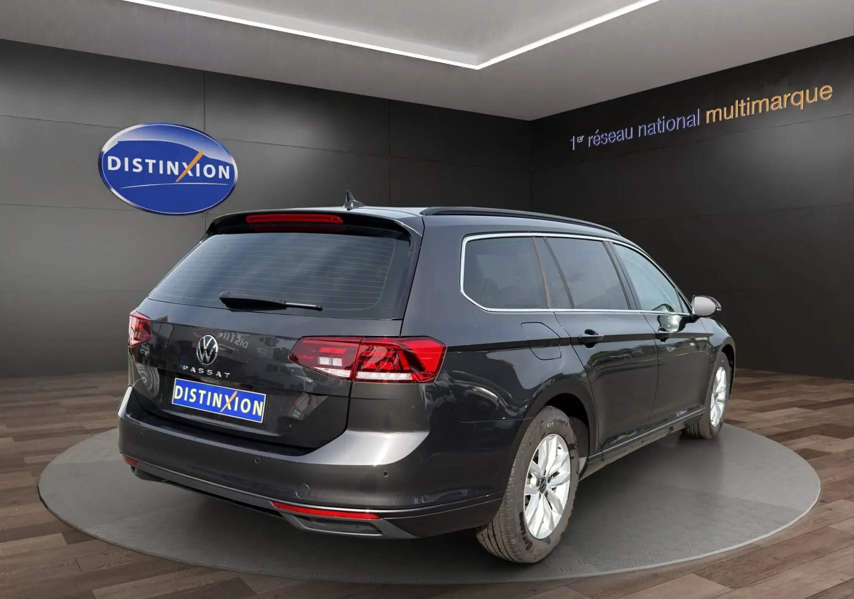 Volkswagen Passat break gris foncé vue 3/4 arrière droit, feux LED et vitres arrière teintées visibles.