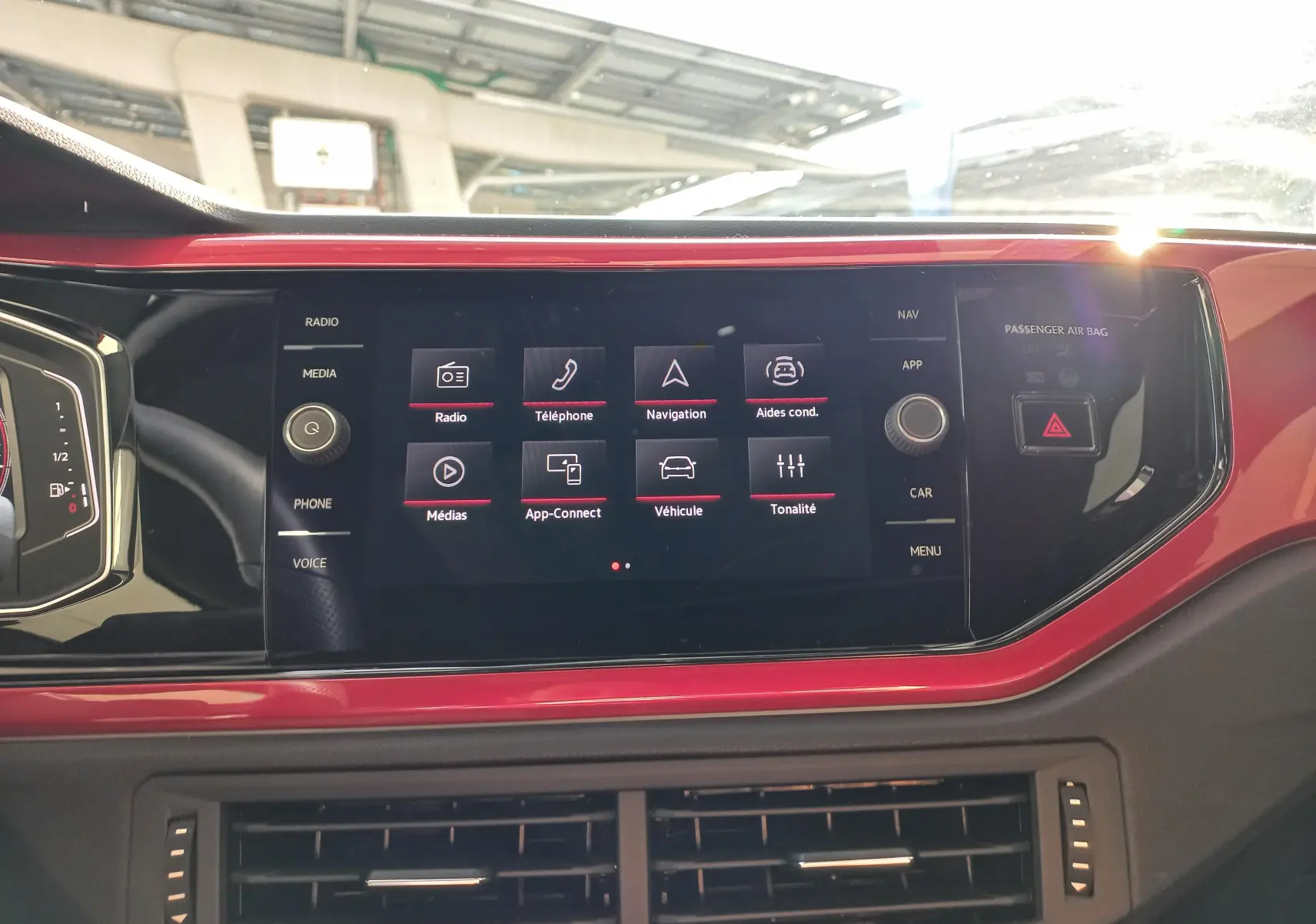 Vue rapprochée de l’écran tactile central rouge de la Volkswagen Polo GTI 2024 avec interface multimédia affichée.