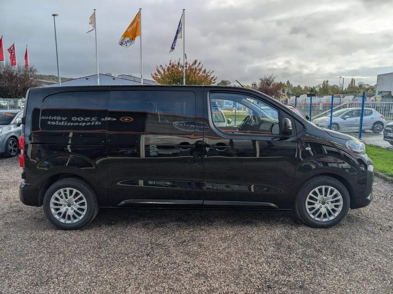 Profil côté gauche d'un Peugeot Expert Fourgon noir 2025 avec portes coulissantes et jantes tôles argentées.