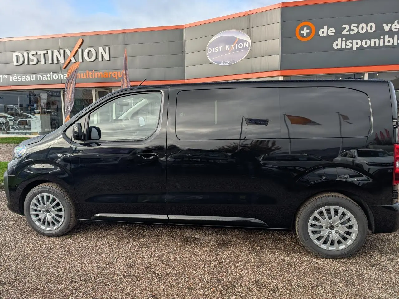 Profil côté gauche du Peugeot Expert Fourgon noir 2025 avec jantes tôle argentées et vitres latérales surteintées.