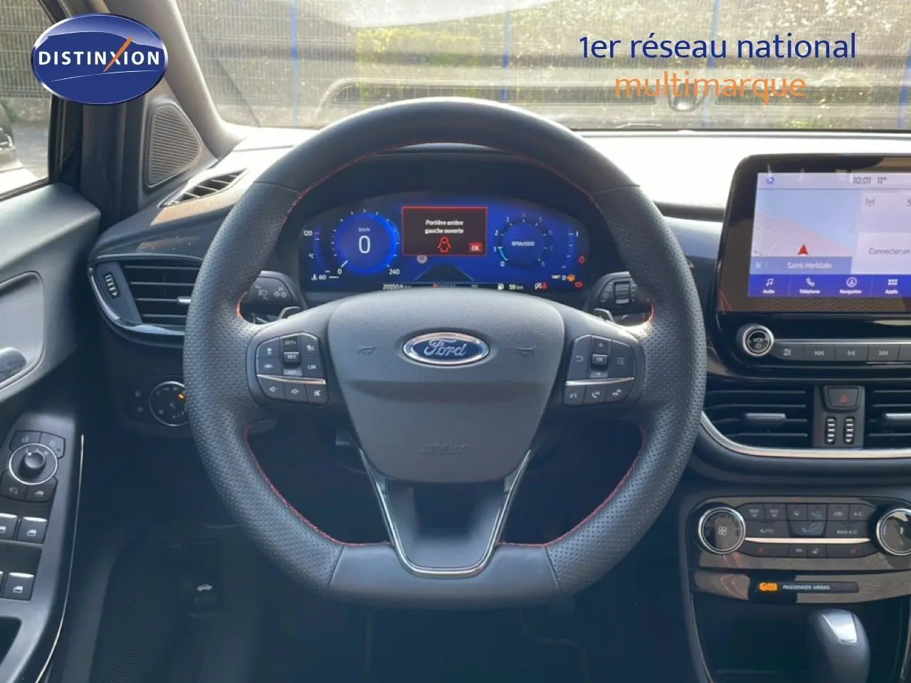 Vue intérieure centrée sur le volant noir du Ford Puma 2023 avec tableau de bord digital et écran tactile.
