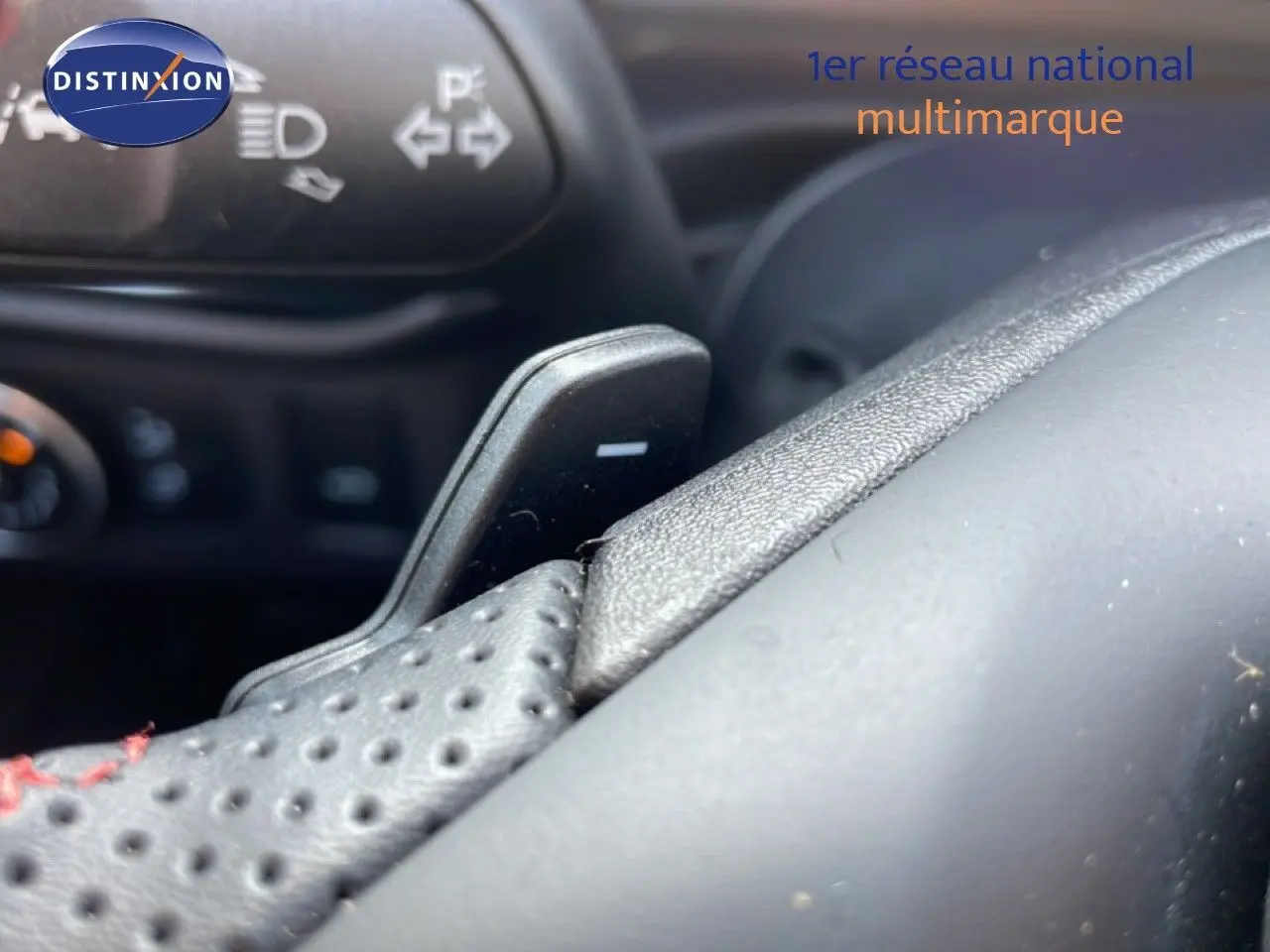 Gros plan sur le volant perforé noir avec palettes de changement de vitesse dans l’habitacle du Ford Puma noir Agate Metal 2023.