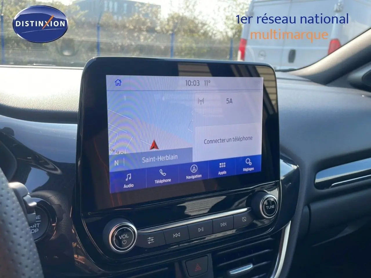 Vue intérieure centrée sur l'écran tactile du système multimédia du Ford Puma noir agate métal, avec tableau de bord moderne.