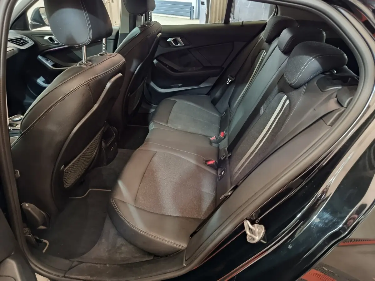 Vue intérieure côté droit des sièges arrière en cuir noir de la BMW Série 1 118i Edition Sport 2023.