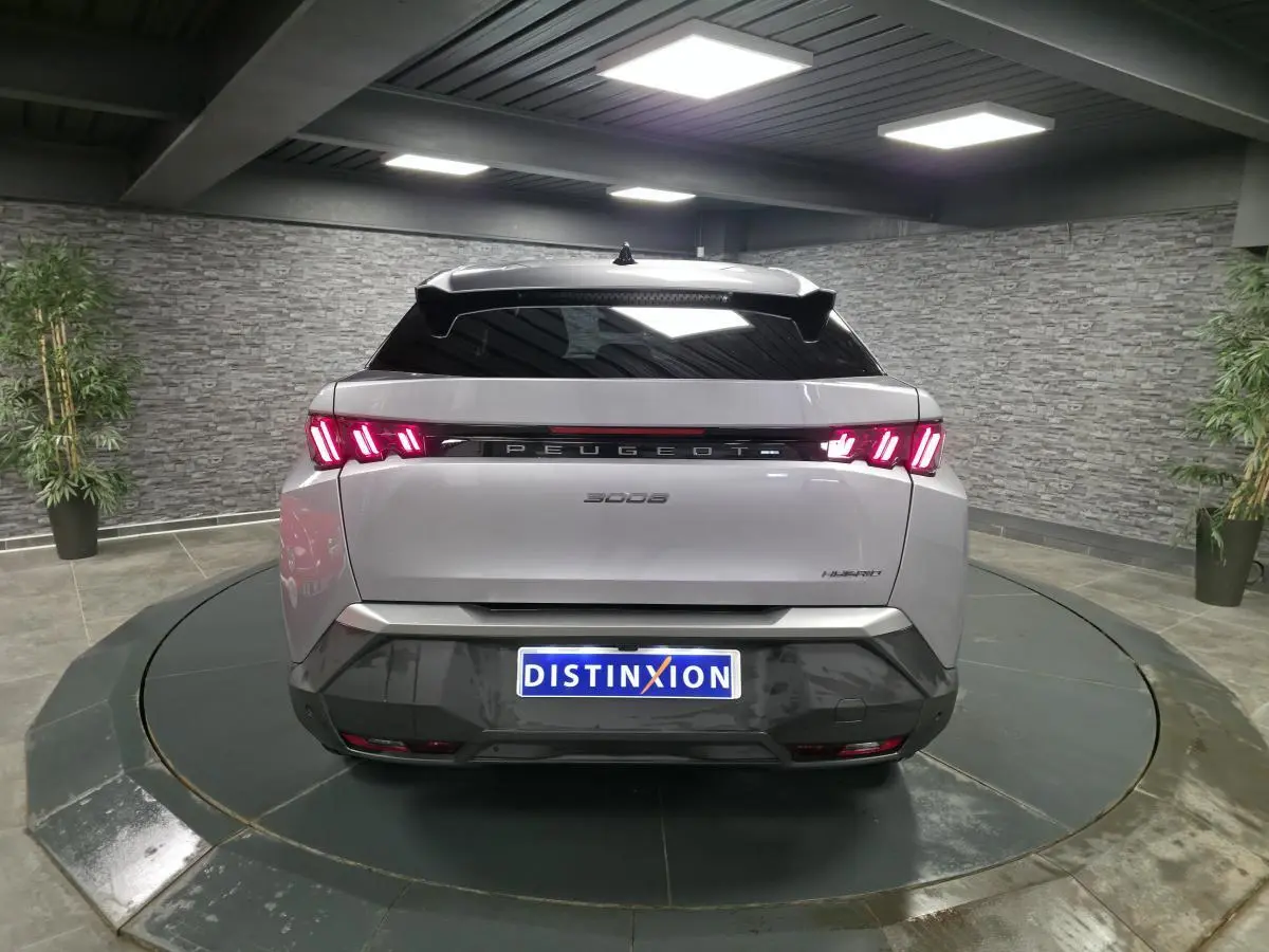 Vue arrière d'un Peugeot 3008 gris métallisé 2025 avec feux arrière LED 3 griffes et bandeau noir laqué.
