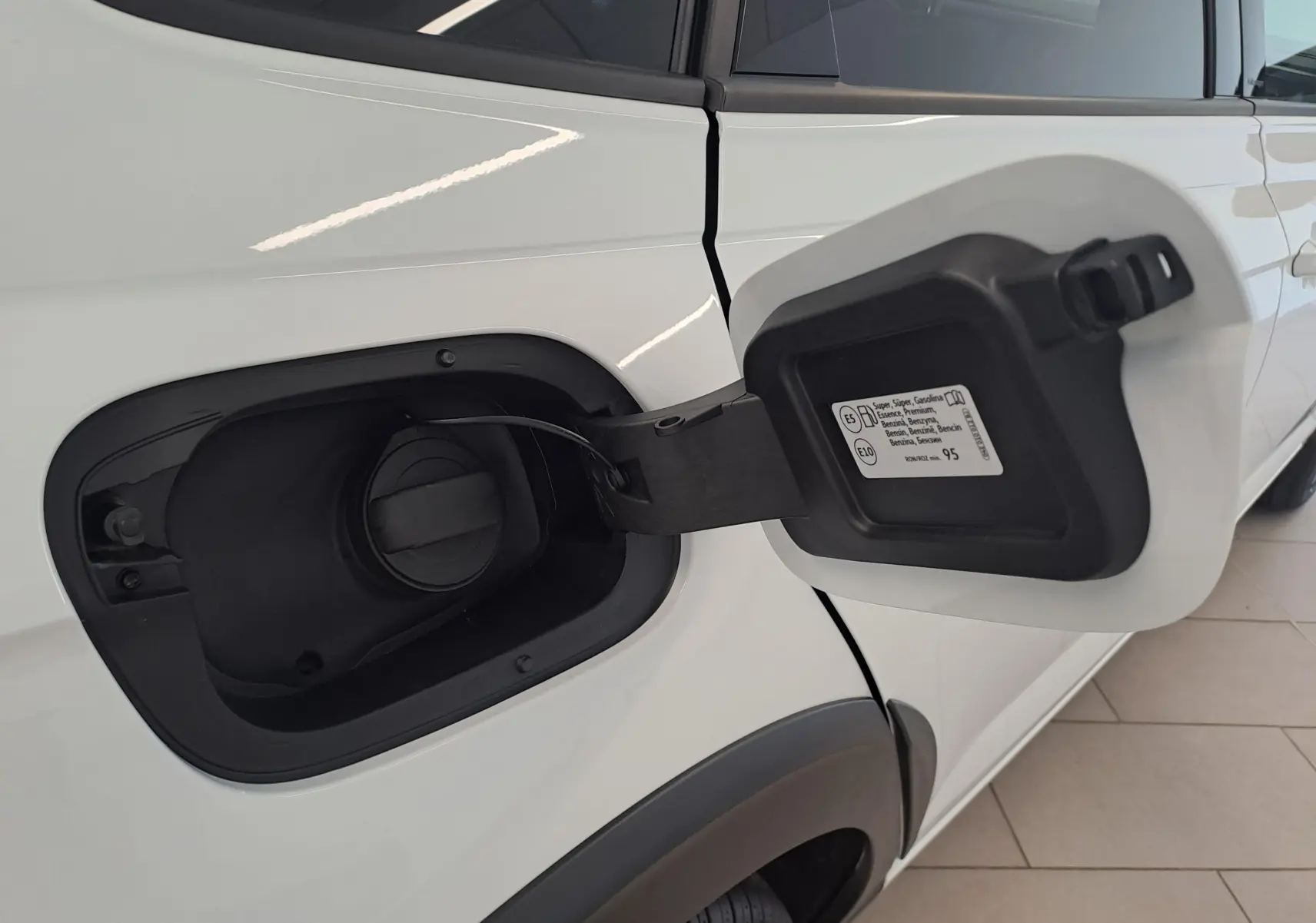 Détail de la trappe à carburant ouverte côté gauche du Volkswagen Taigo blanc pur 2025, version R-Line Edition.