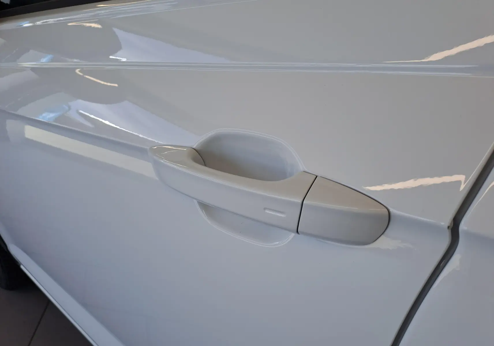 Poignée de porte côté gauche du Volkswagen Taigo blanc pur 2025, finition R-Line Edition, vue rapprochée.