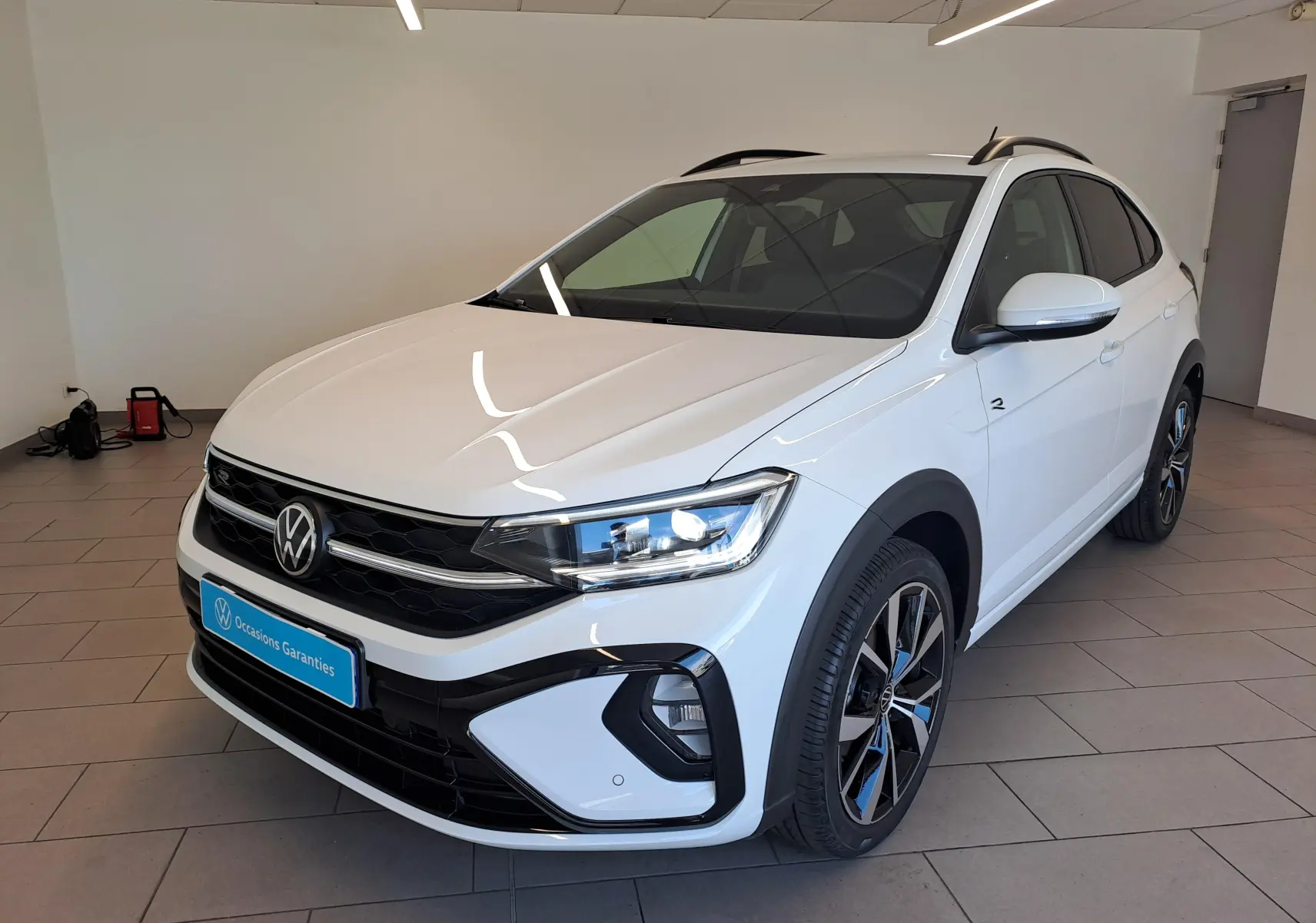 Volkswagen Taigo blanc pur en 3/4 avant droit, avec jantes alliage 18'' Misano et détails R-Line noirs.