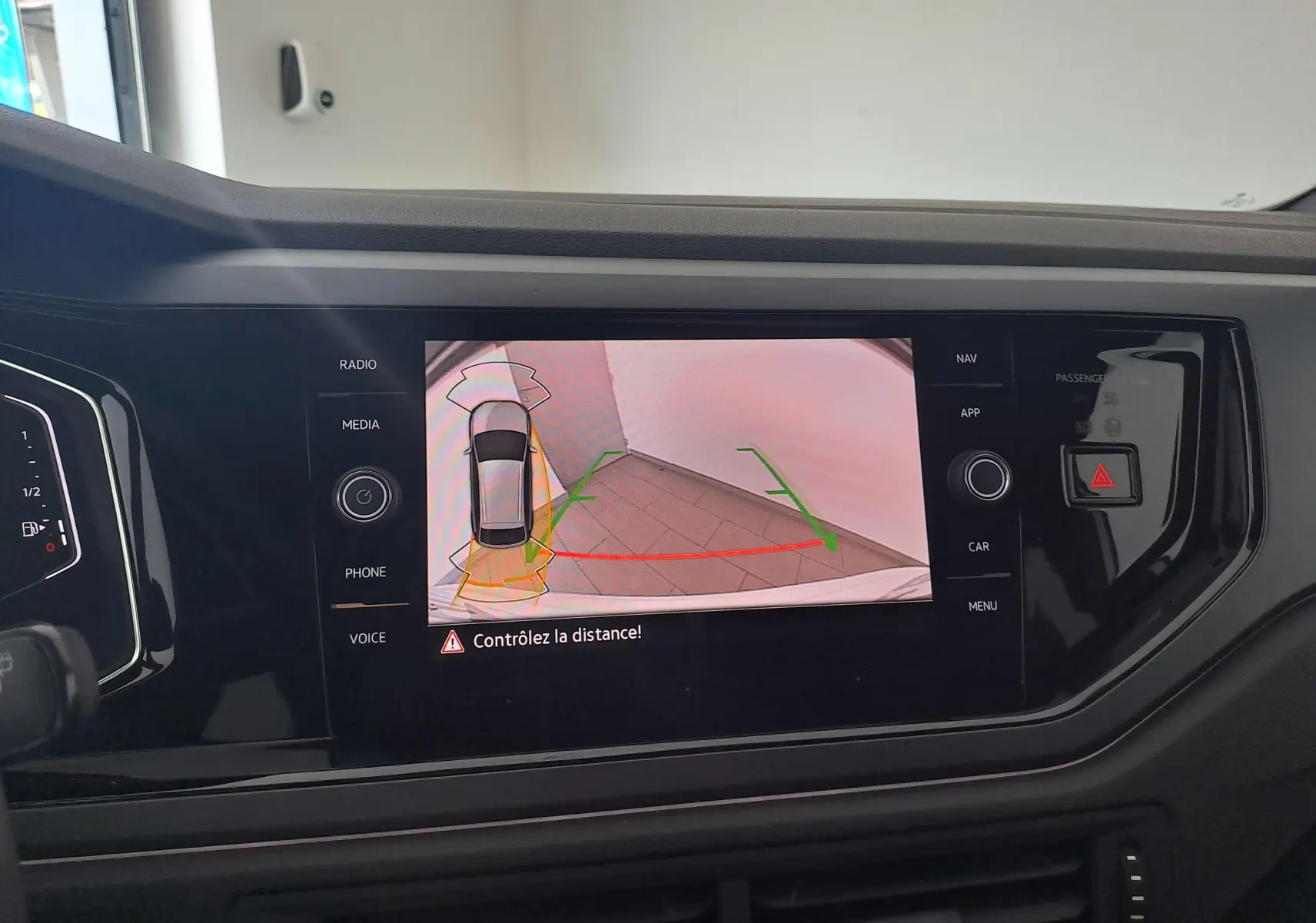 Vue intérieure sur l'écran central du Volkswagen Taigo blanc, affichant la caméra de recul avec guidage dynamique.