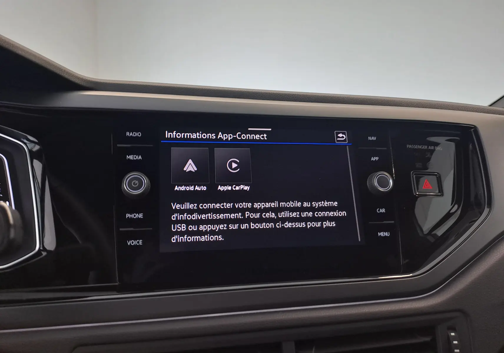 Vue rapprochée de l'écran tactile central du Volkswagen Taigo blanc, affichant les options Android Auto et Apple CarPlay.