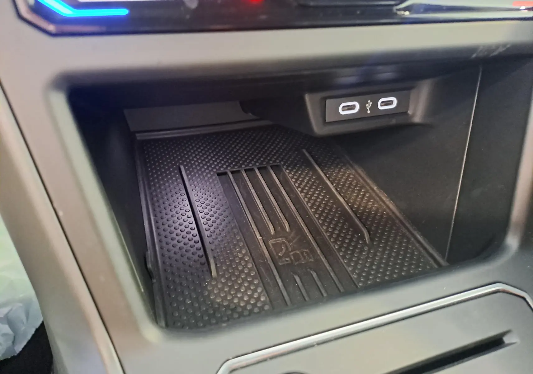 Vue rapprochée de la console centrale du Volkswagen Taigo 2025, avec prise USB double et éclairage LED coloré.