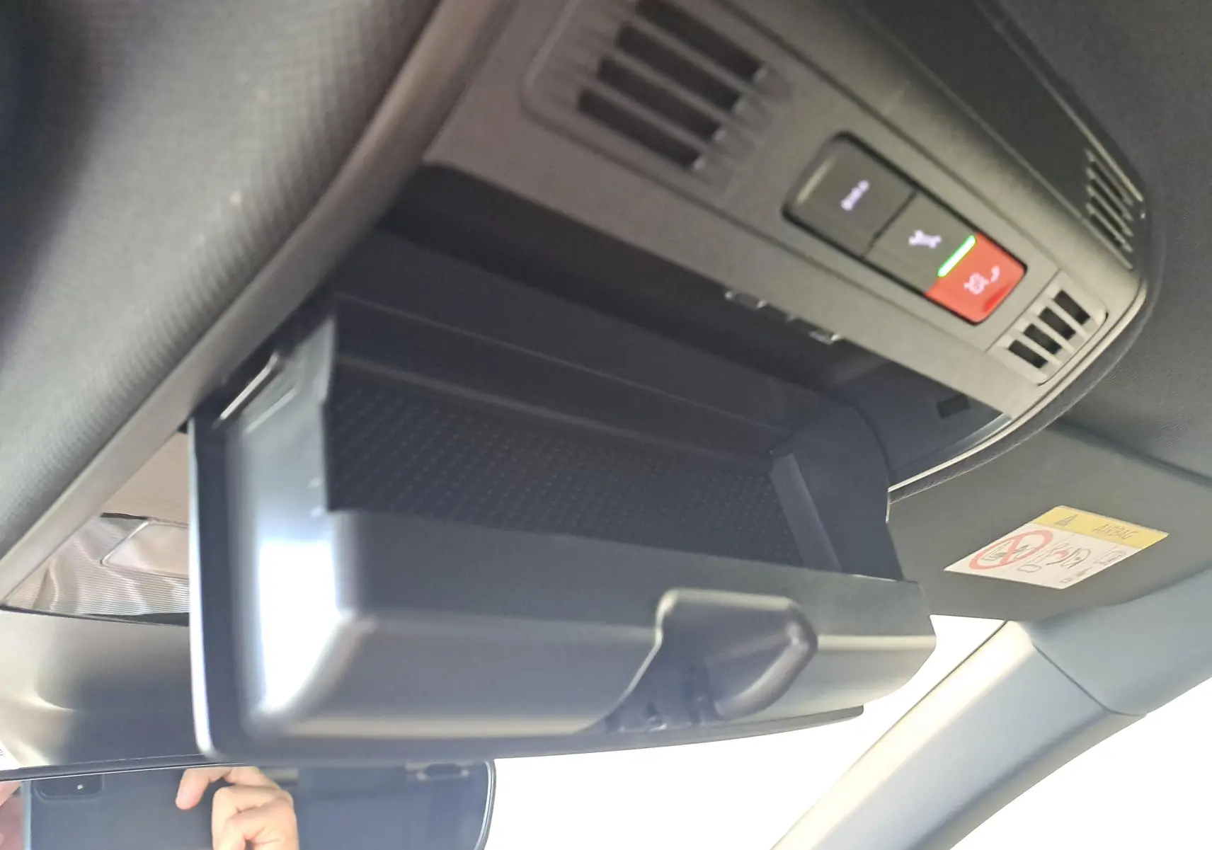 Rangement lunettes ouvert sous le plafonnier avec boutons SOS et assistance dans un Volkswagen Taigo blanc 3/4 avant intérieur.