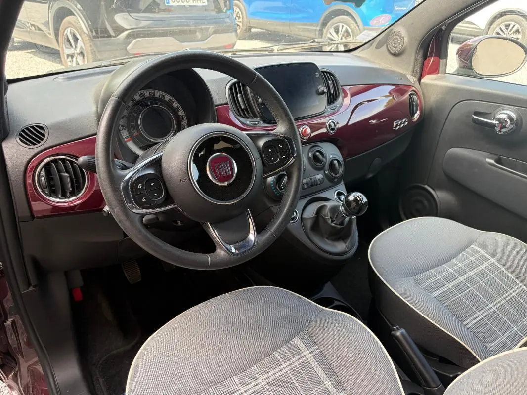 Vue intérieure côté conducteur de la FIAT 500 violet 2019, volant cuir multifonctions et tableau de bord brillant.