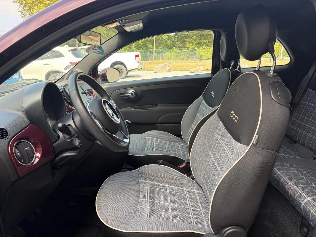 Intérieur de la FIAT 500 violet vue côté conducteur, sièges à motif écossais avec logo 500 brodé, volant cuir multifonctions.