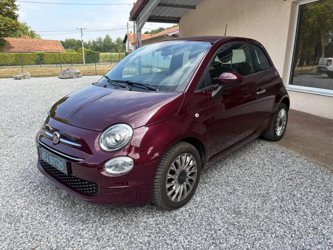 Vue 3/4 avant droit d'une FIAT 500 berline violet foncé 2019 avec jantes alliage et rétroviseurs assortis.