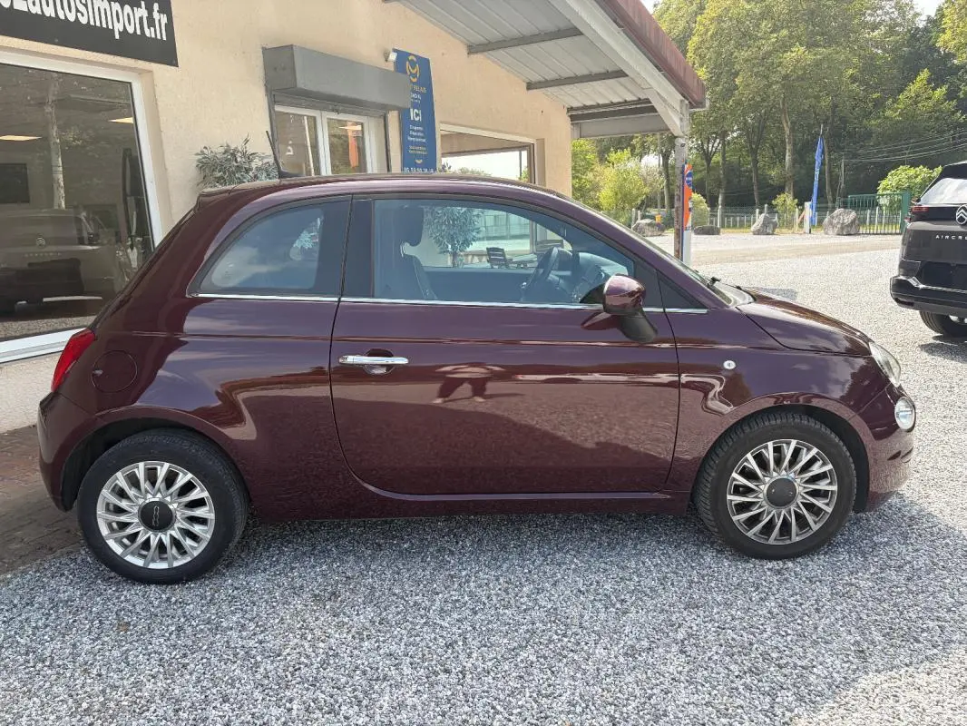 Profil côté gauche d'une FIAT 500 berline violet foncé 2019 avec jantes alliage et rétroviseurs assortis.
