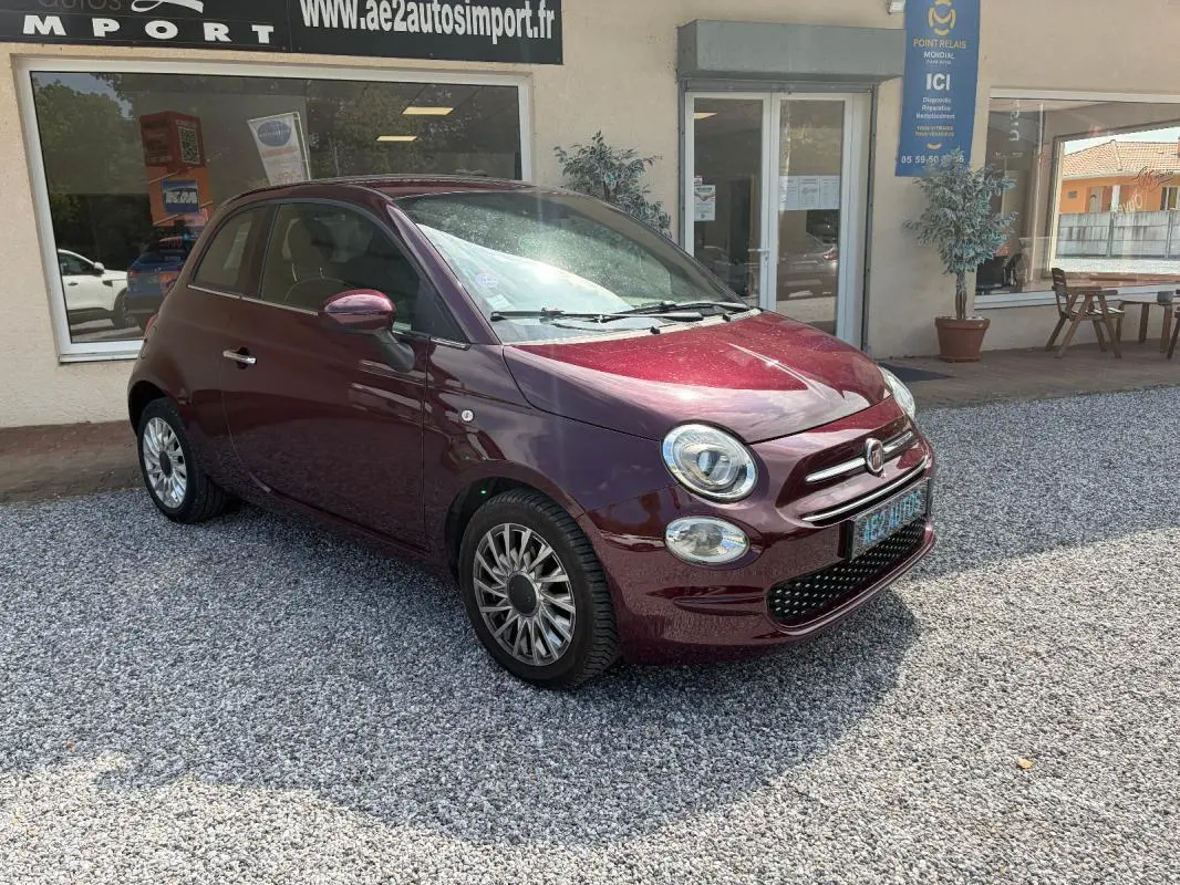 Fiat 500 berline violet vue 3/4 avant droit, avec jantes alliage et détails chromés sur calandre et phares.