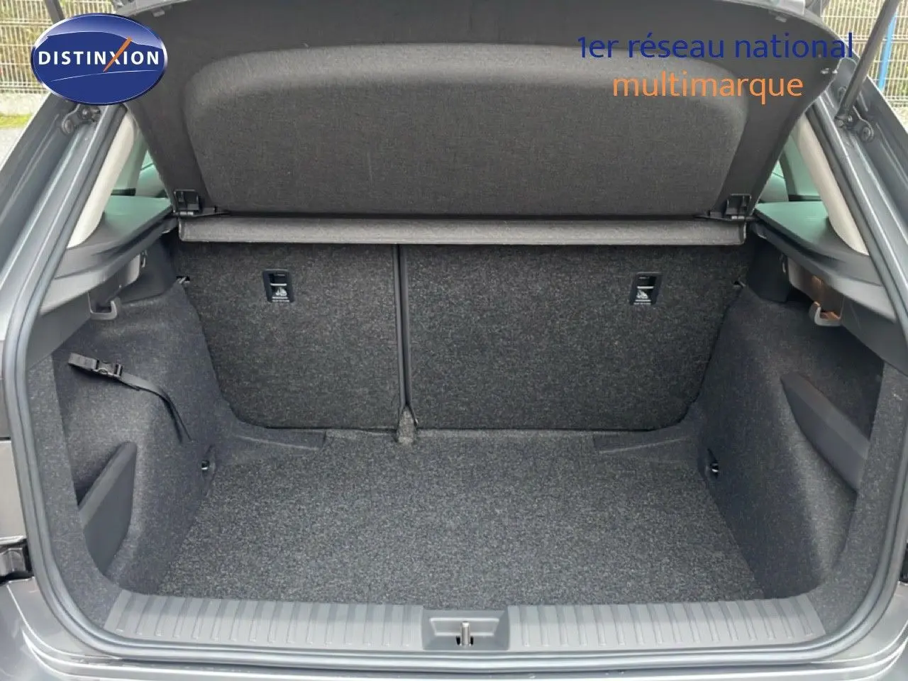 Coffre ouvert d'un Skoda Kamiq gris graphite, vue arrière montrant l'espace de chargement et la moquette intérieure.