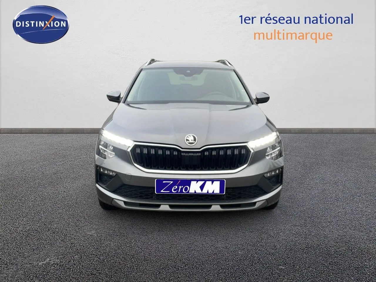 Vue frontale d'un Skoda Kamiq gris graphite 2025 avec feux LED allumés et calandre noire distinctive.
