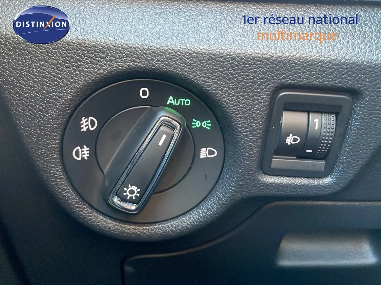 Gros plan sur la commande des phares du Skoda Kamiq 2024, avec réglage automatique et molette de réglage d’intensité.