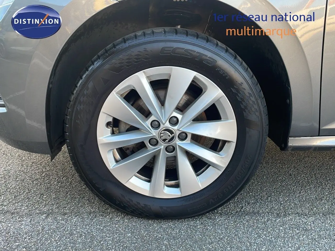 Gros plan sur la roue avant gauche avec jante alliage argentée du Skoda Kamiq gris graphite métal 2024.