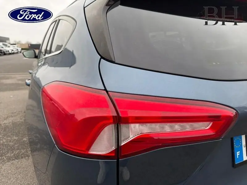 Vue arrière côté gauche d'une Ford Focus SW 2019 bleu azur métallisé avec feu arrière distinctif et vitre teintée.