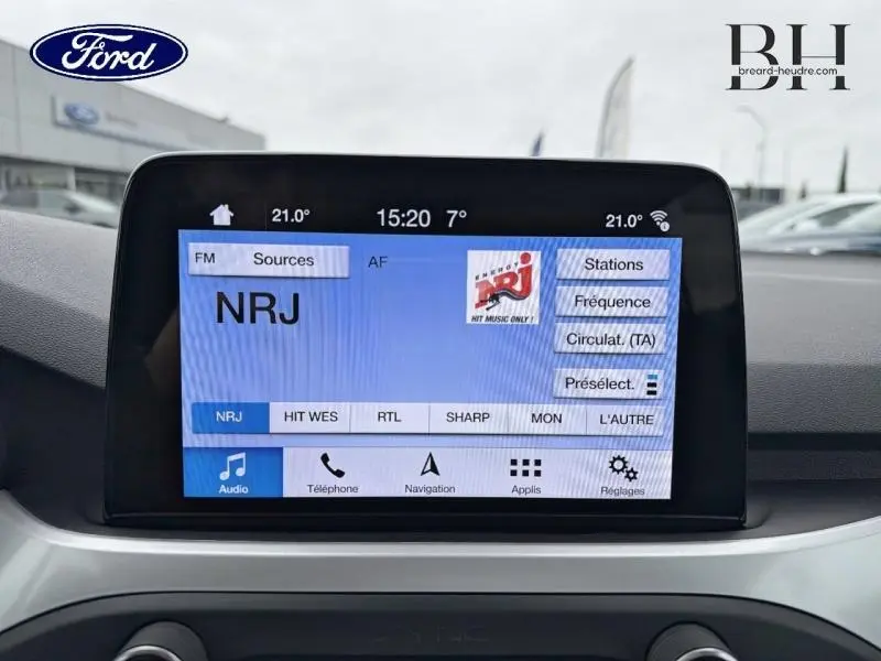Écran tactile central de la Ford Focus SW 2019 affichant la radio NRJ, vue intérieure avant du tableau de bord.