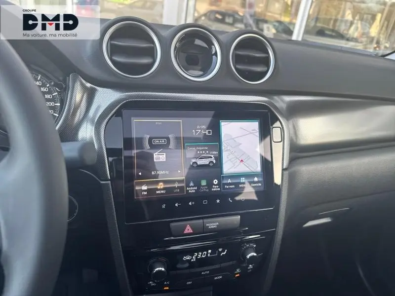 Vue intérieure du tableau de bord du Suzuki Vitara 1.4 Boosterjet Hybrid 2026 avec écran tactile et aérateurs ronds chromés.
