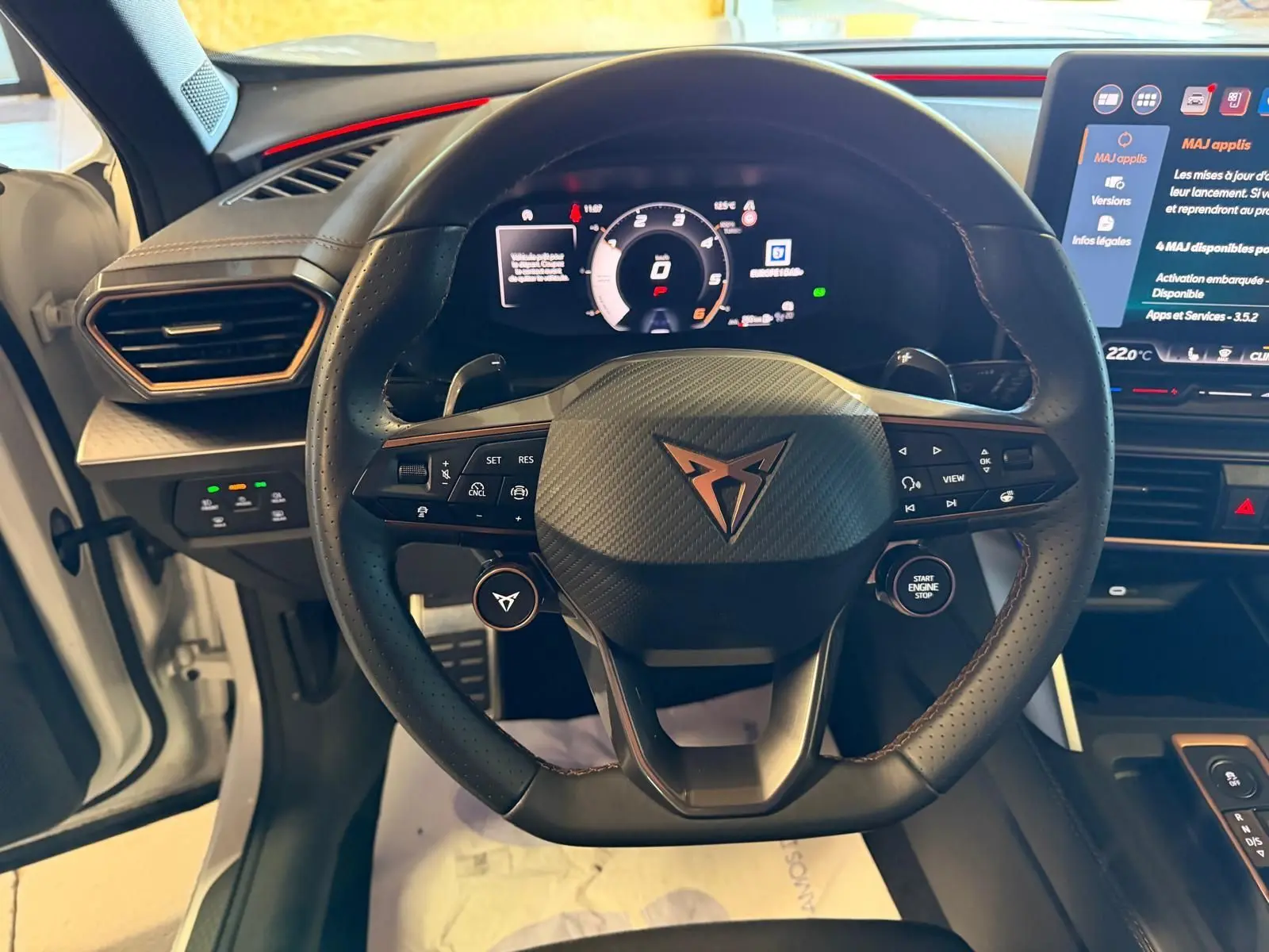 Vue frontale du volant cuir noir perforé avec logo CUPRA, tableau de bord digital et écran tactile du CUPRA Formentor blanc 2025.