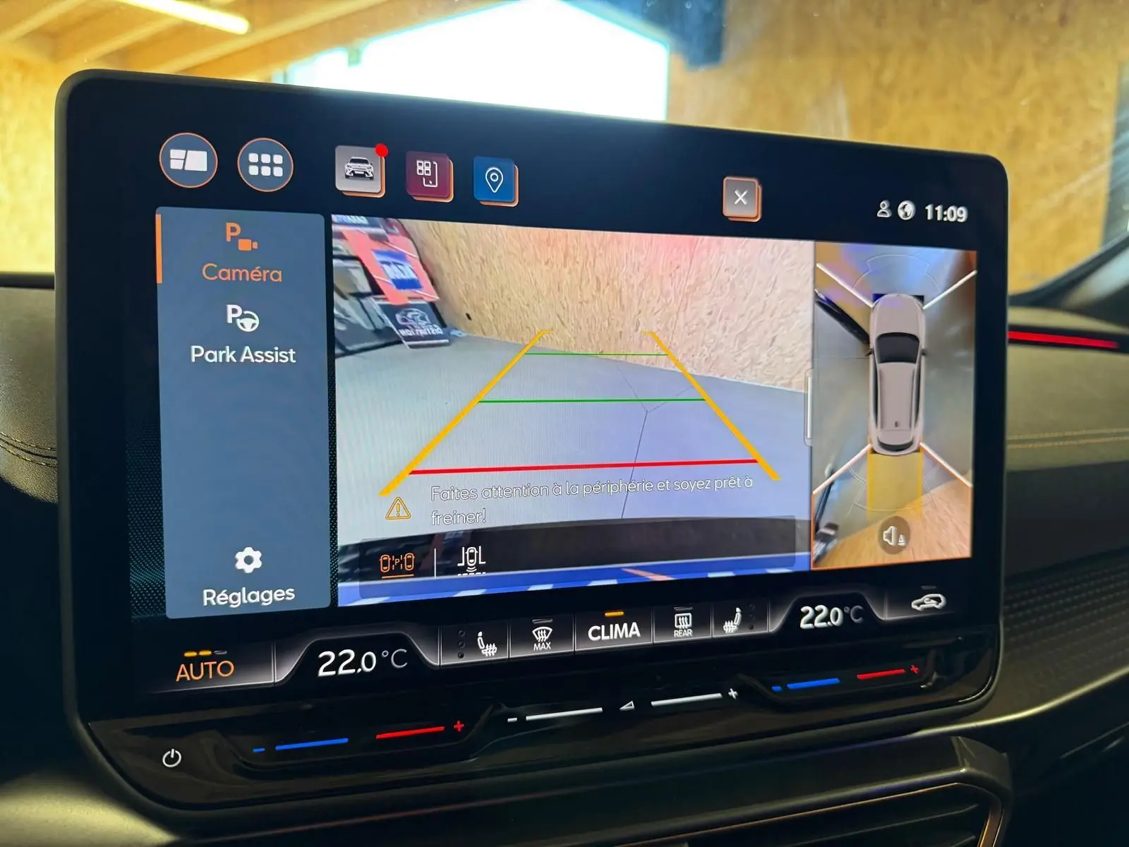 Écran tactile intérieur affichant l'aide au stationnement avec vue caméra et capteurs du CUPRA Formentor blanc.