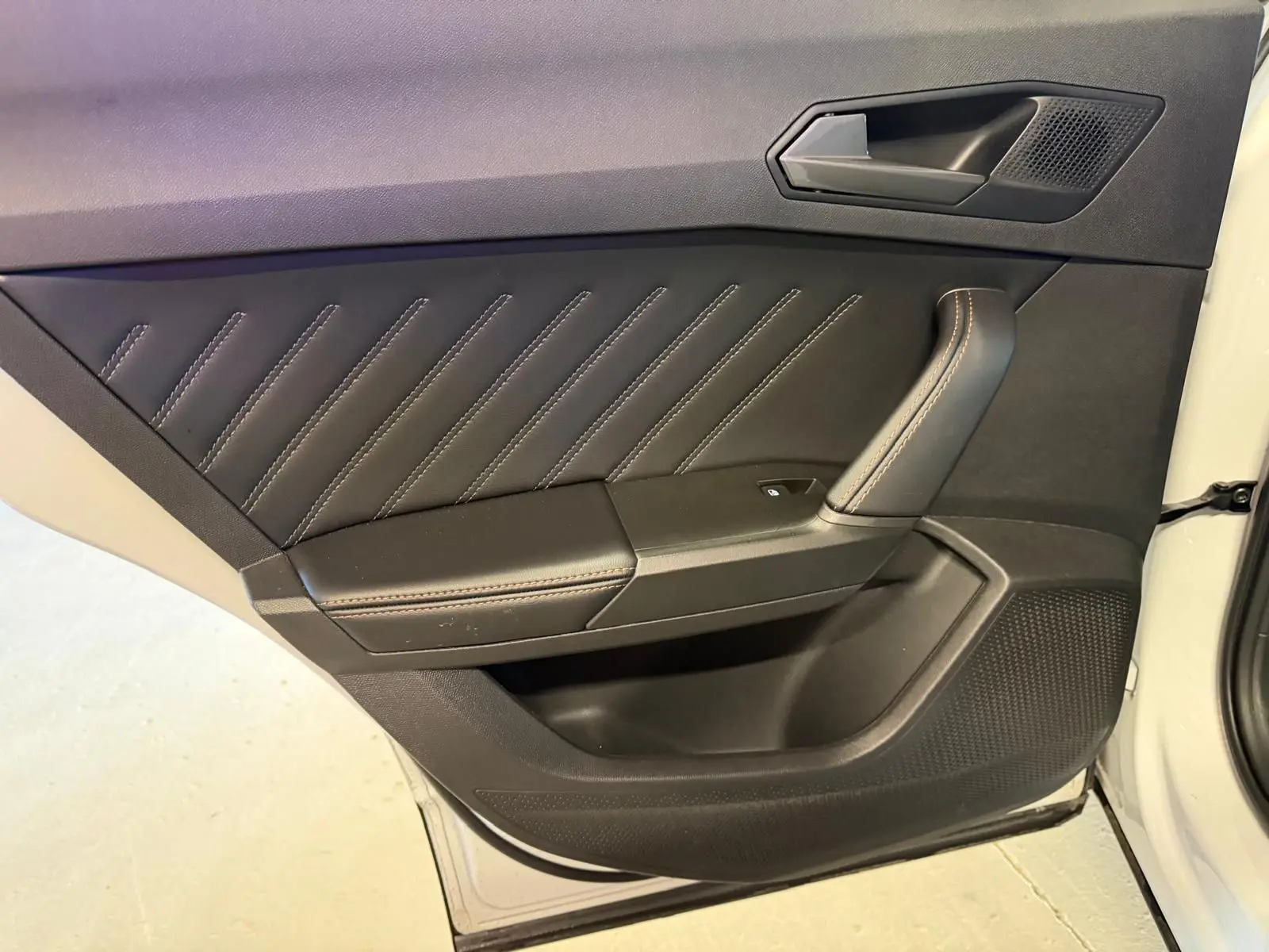Gros plan sur la porte avant droite blanche du CUPRA Formentor 2025, avec garniture noire et surpiqûres contrastées.