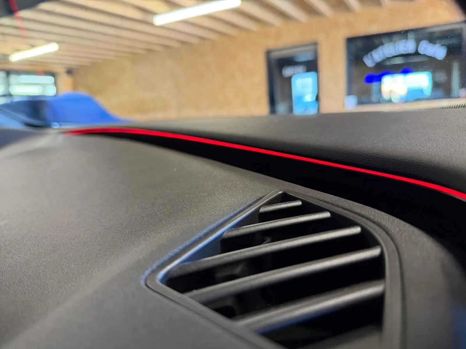 Gros plan sur la sortie d'air et la bande lumineuse rouge du tableau de bord du CUPRA Formentor blanc 2025.