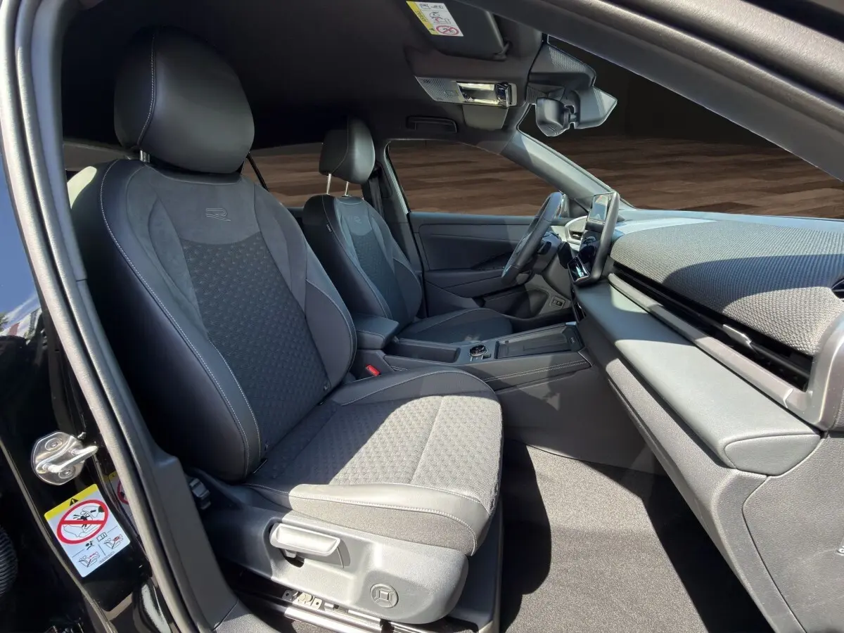 Vue intérieure côté conducteur du Volkswagen T-Roc noir 2026, mettant en valeur les sièges sport R et le tableau de bord moderne.