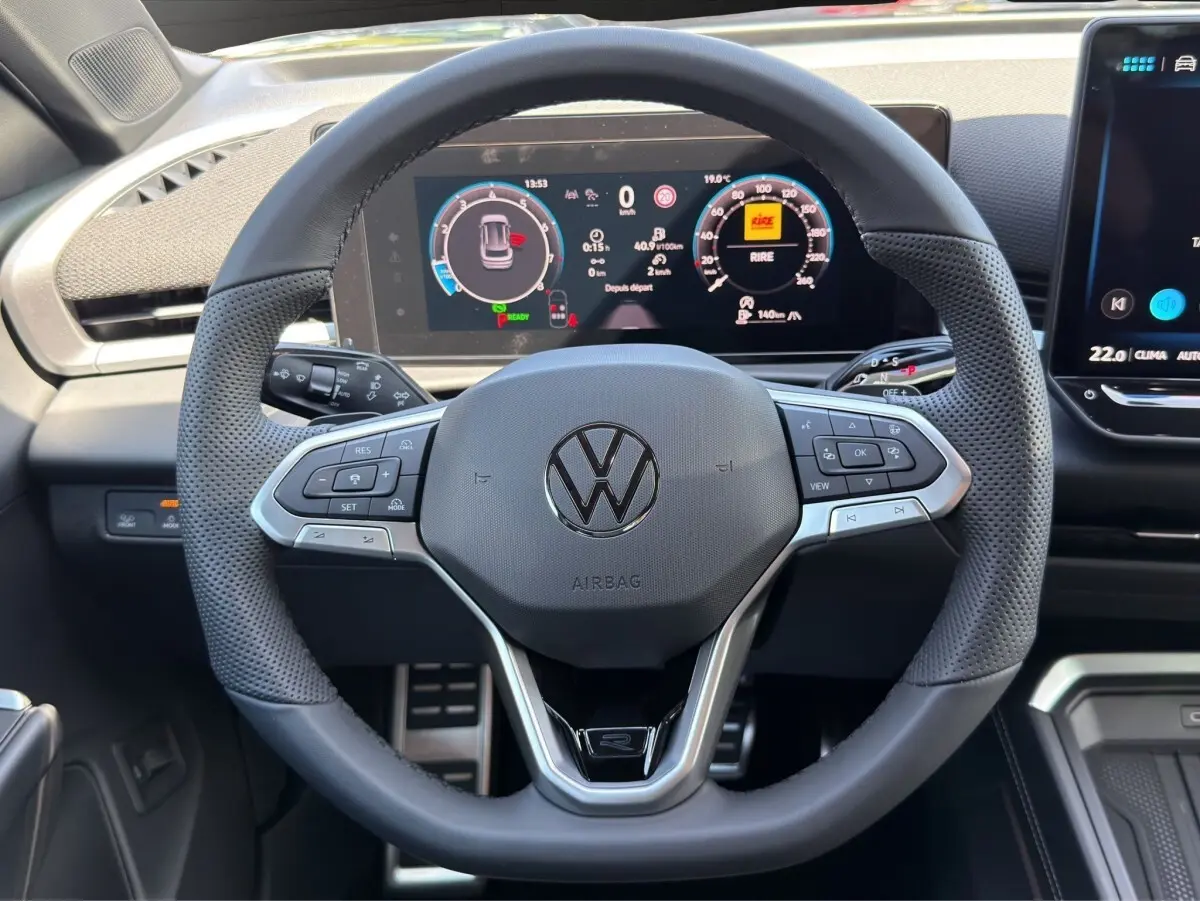 Vue rapprochée du volant cuir noir multifonctions du Volkswagen T-Roc 2026 avec tableau de bord numérique affiché.