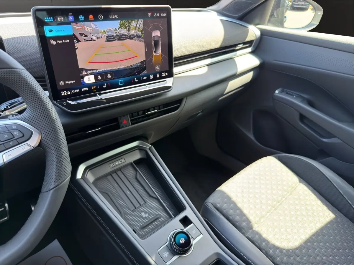 Vue intérieure côté passager du Volkswagen T-Roc noir 2026, avec écran tactile central affichant l'aide au stationnement.