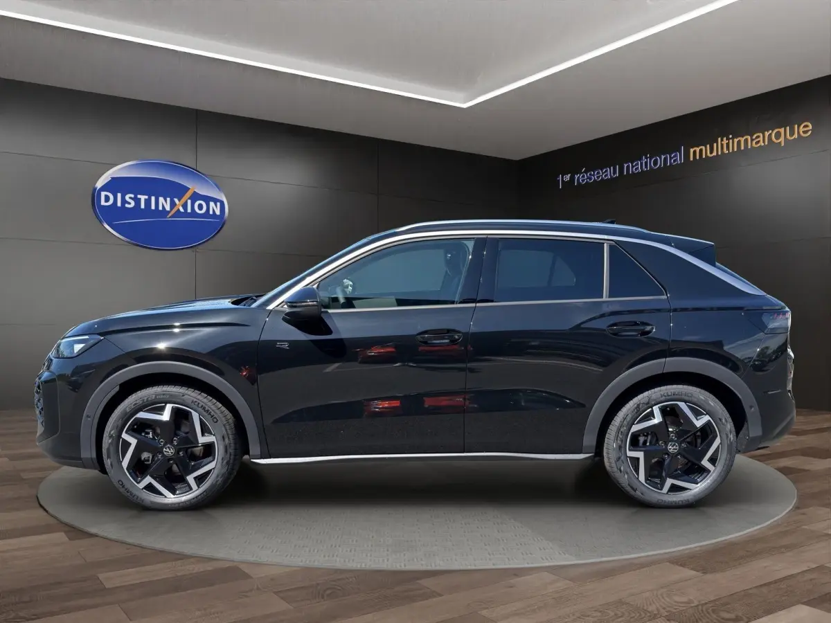 Vue de profil côté gauche du Volkswagen T-Roc noir 2026 avec jantes alliage et toit panoramique.