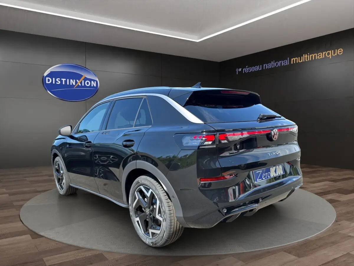 Vue 3/4 arrière droite d’un Volkswagen T-Roc noir 2026 avec feux arrière LED et jantes alliage distinctives.