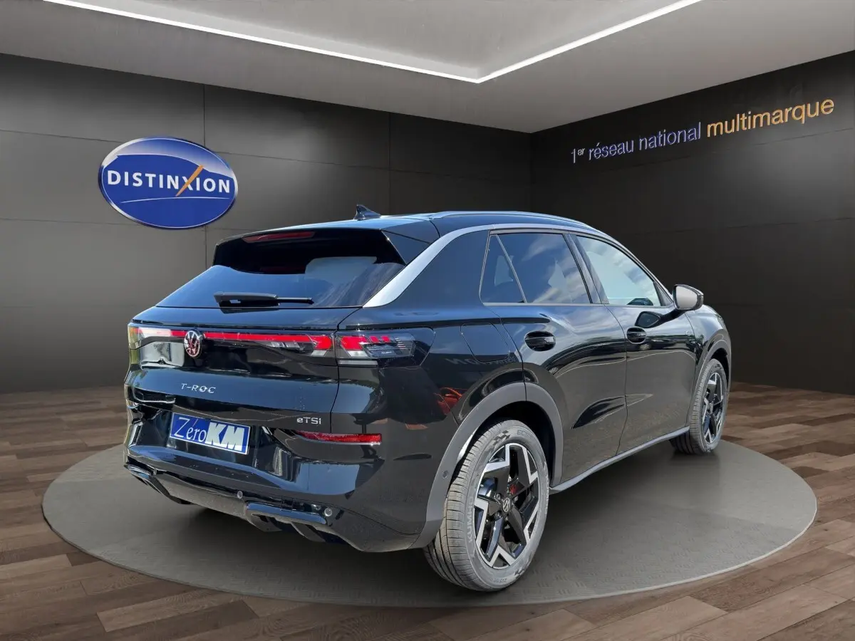 Vue 3/4 arrière droite du Volkswagen T-Roc noir 2026 avec jantes alliage et feux arrière LED distinctifs.