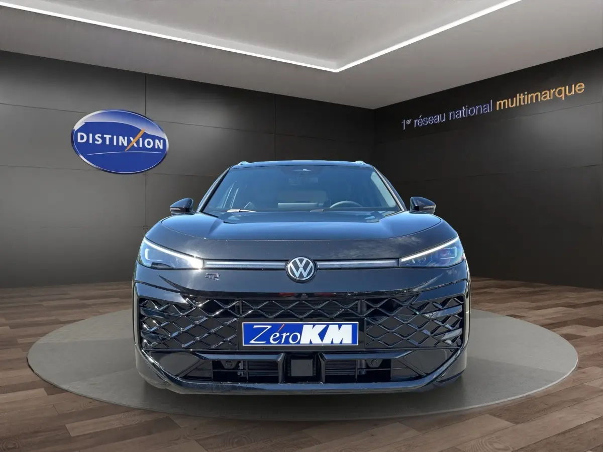 Vue frontale d'un Volkswagen T-Roc noir 2026 avec calandre ajourée et phares LED fins allumés.