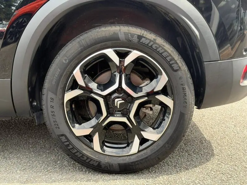 Gros plan sur la roue arrière droite noire Perla Nera du Citroën C5 Aircross 2024 avec jante alu bicolore distinctive.
